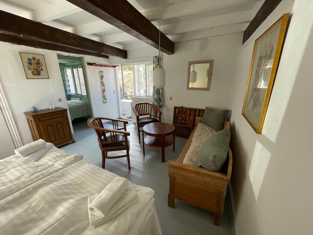 Schlafzimmer mit einem Bett, einem Tisch und Stühlen in der Unterkunft JANTZENs HOTEL in Gudhjem