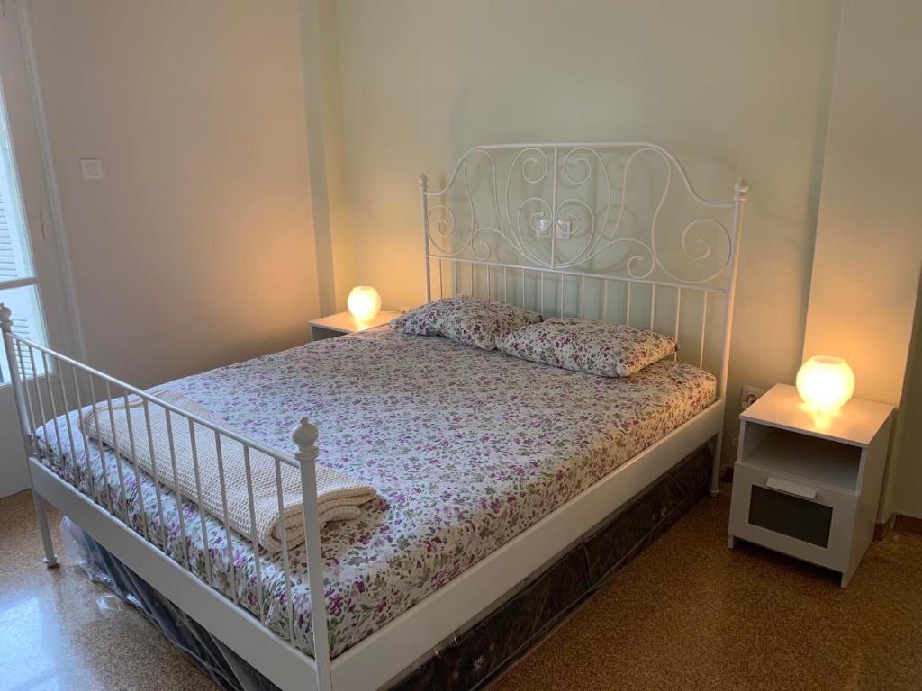 um quarto com uma cama branca com duas mesas de cabeceira em Lillian’s House em Atenas