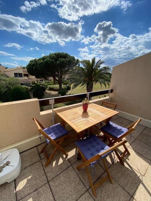 une table et des chaises en bois sur un balcon dans l'établissement Grand studio entre le golf et la plage à 800m, à Saint Cyprien Plage