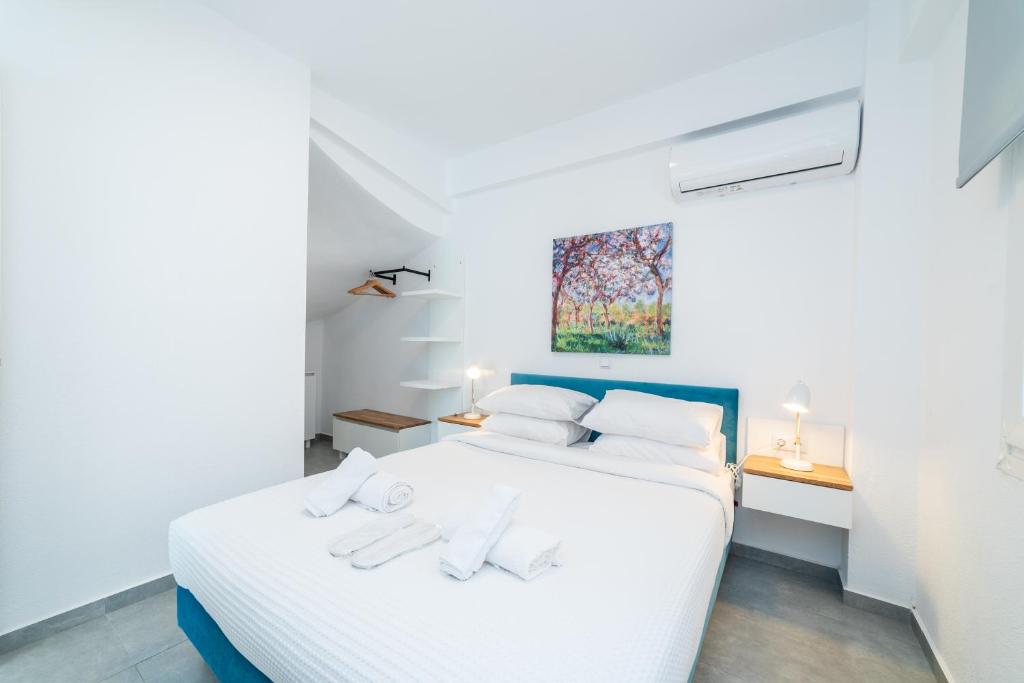 ein Schlafzimmer mit einem weißen Bett mit zwei Handtüchern darauf in der Unterkunft Dionysos Residential Complex in Ofrynio