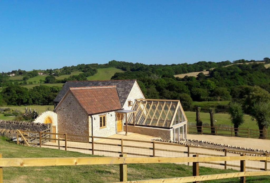 a small building with a solarium on top of a field at Goose Run Cottage in Corscombe