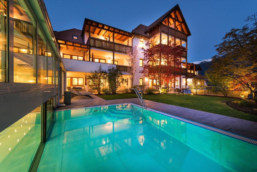 a house with a swimming pool in front of a building at Residence Landhaus Fux in Silandro