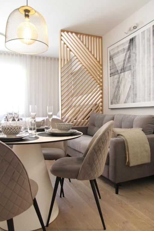 uma sala de estar com uma mesa e um sofá em JU3 Apartments em Liubliana