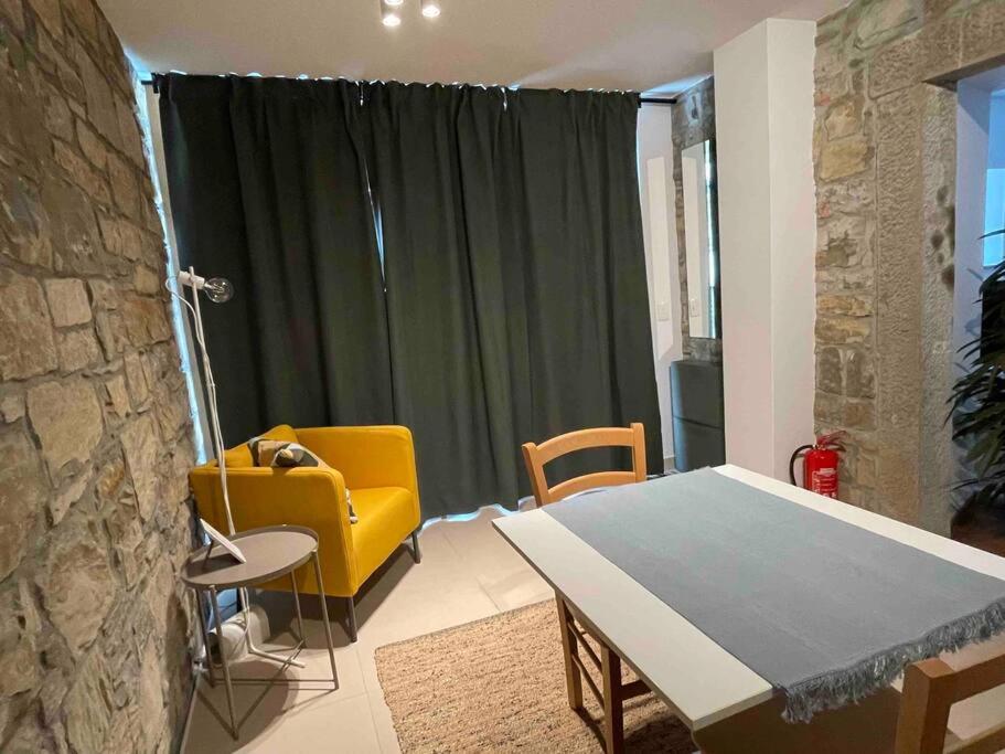 a living room with a table and a yellow chair at Santomas apartments in Šmarje