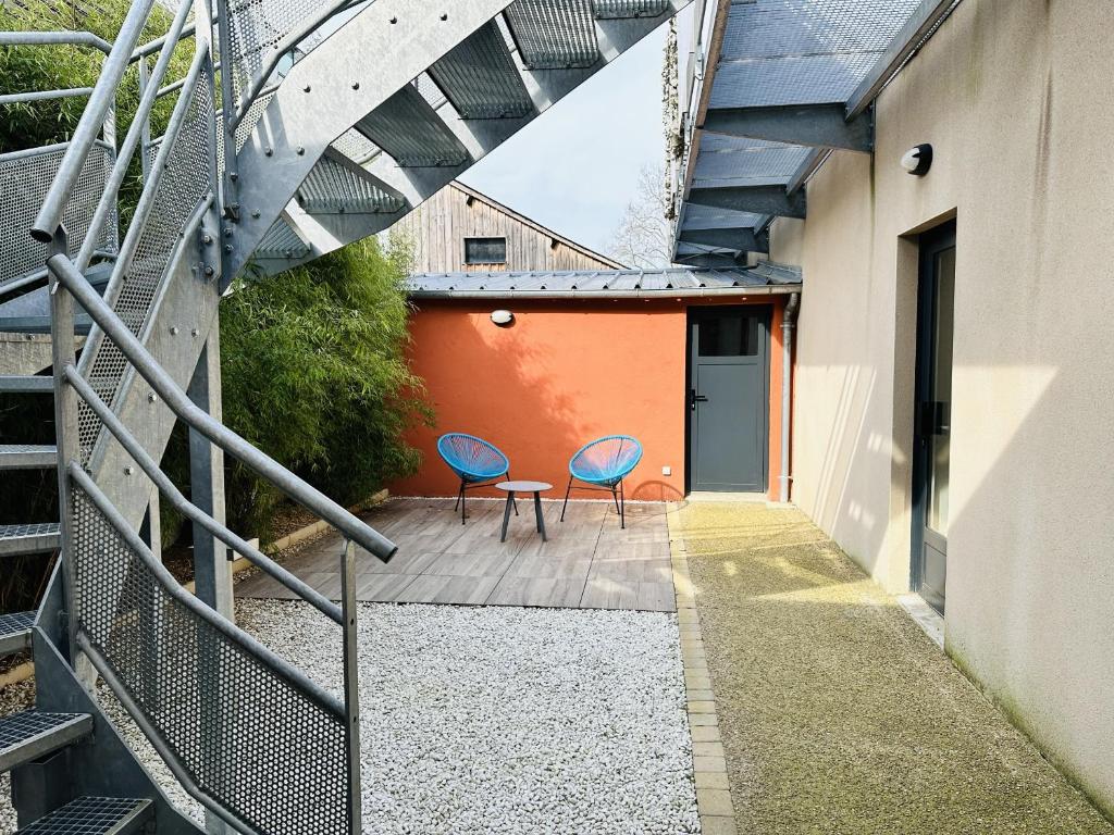 two chairs and a table on a patio next to a building at Le Patio de Loiseau in Le Mans