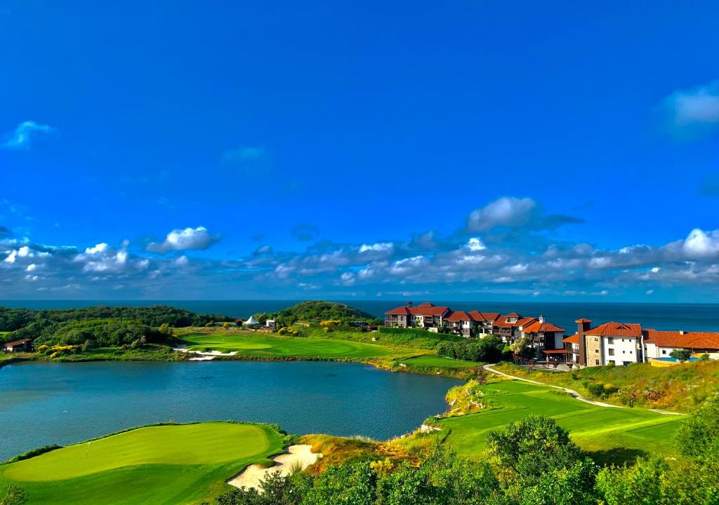 a view of a golf course with a lake and houses at Thracian Cliffs Private Apartment in Kavarna