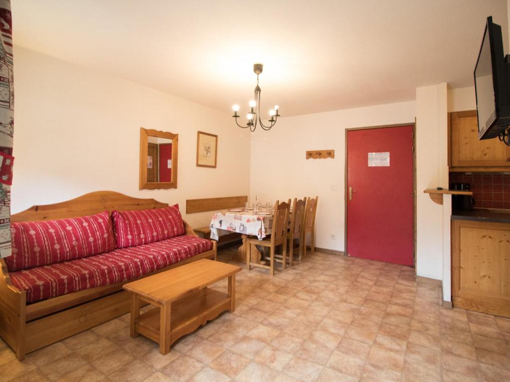 un salon avec un canapé rouge et une table dans l'établissement Appartement cosy au pied des pistes - 6 pers, 40m², terrasse, parking, proche commerces et services - FR-1-508-13, à Lanslevillard