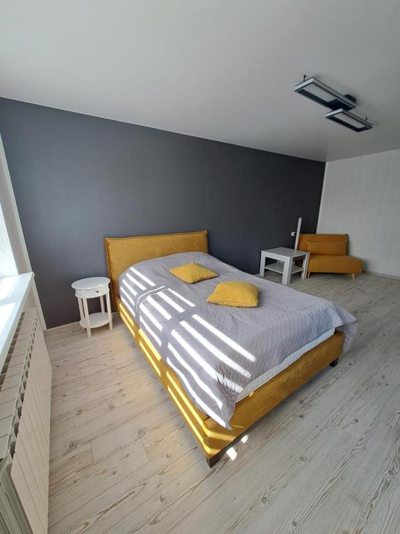 um quarto com uma cama grande e almofadas amarelas em Rakvere studio em Narva