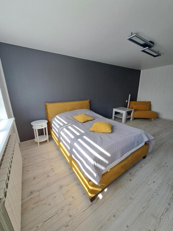 a bedroom with a large bed with yellow pillows at Rakvere studio in Narva