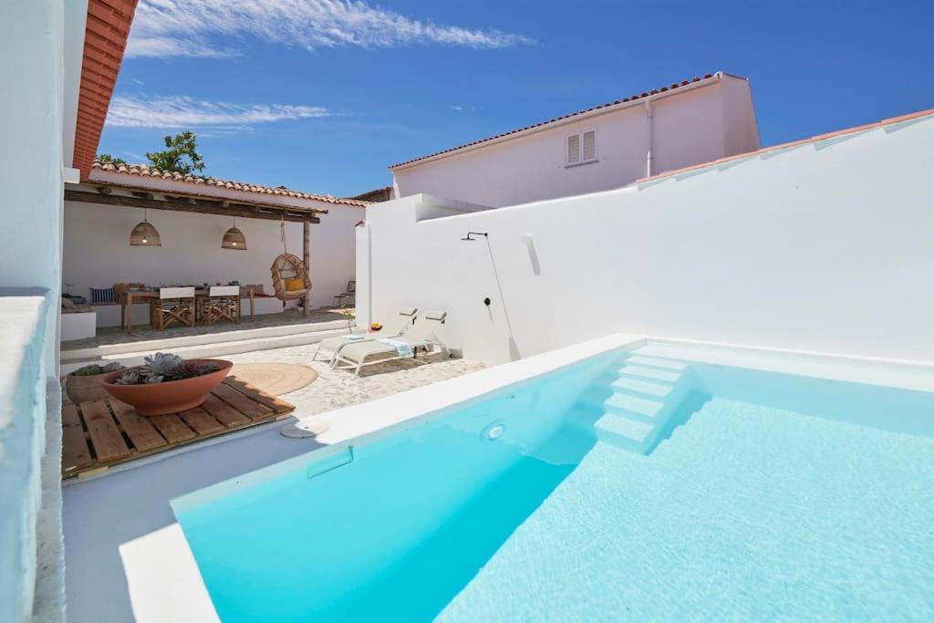 a swimming pool in front of a house at Rustic & Aesthetic House in Alqueva with Pool in Granja