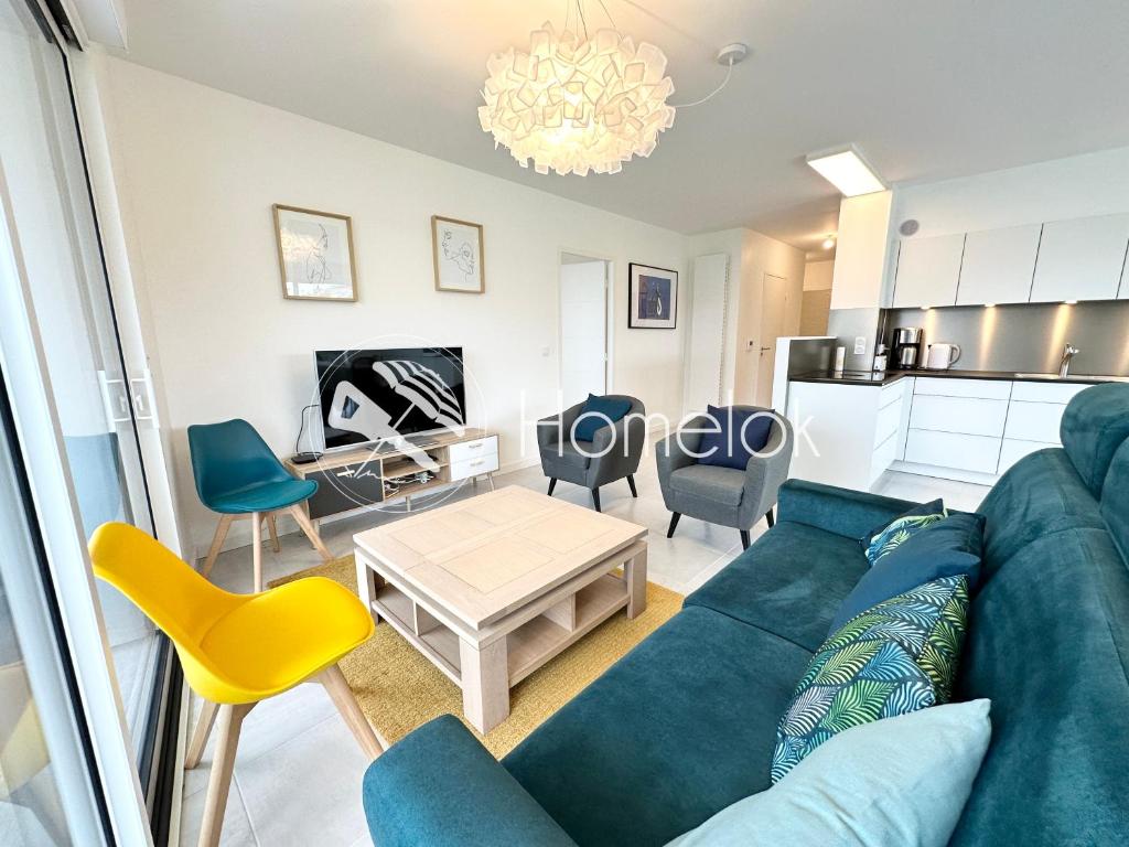 un soggiorno con divano blu e tavolo di Grand appartement neuf de standing – Top Cosy a Larmor-Plage