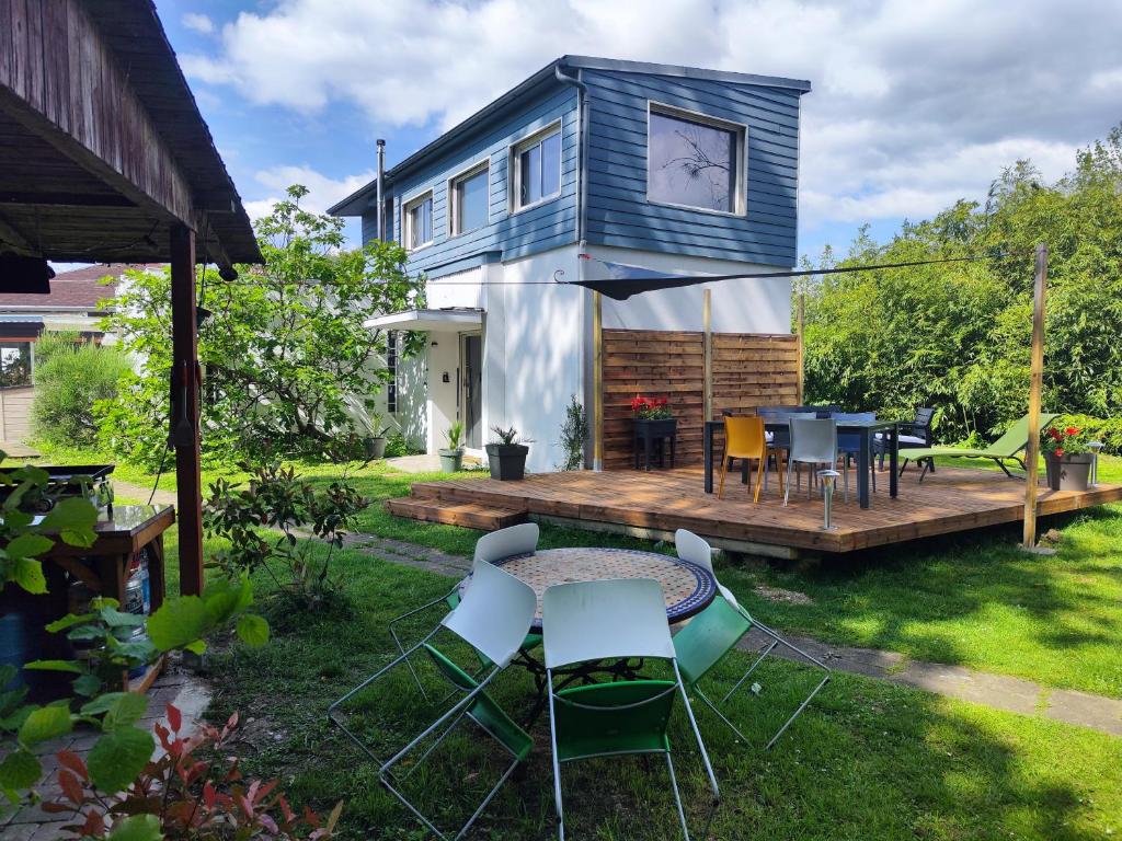 ein blaues Haus mit einer Terrasse mit einem Tisch und Stühlen in der Unterkunft Gîte du Moulin de Tart le Bas 