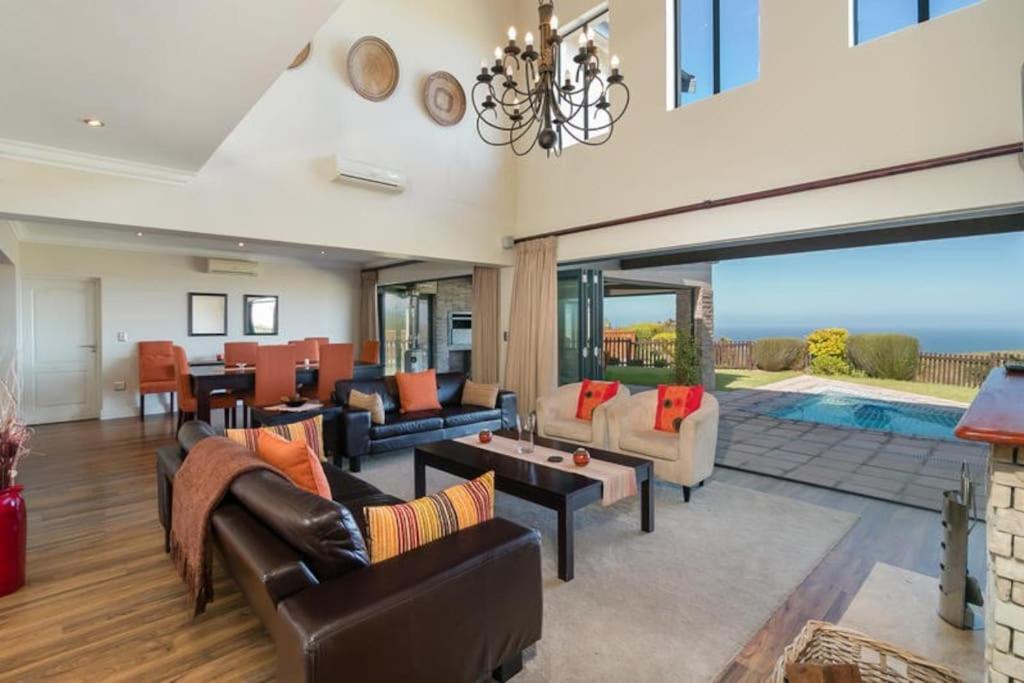 a living room filled with furniture and a pool at Pezula Luxury Villa SW2 in Knysna