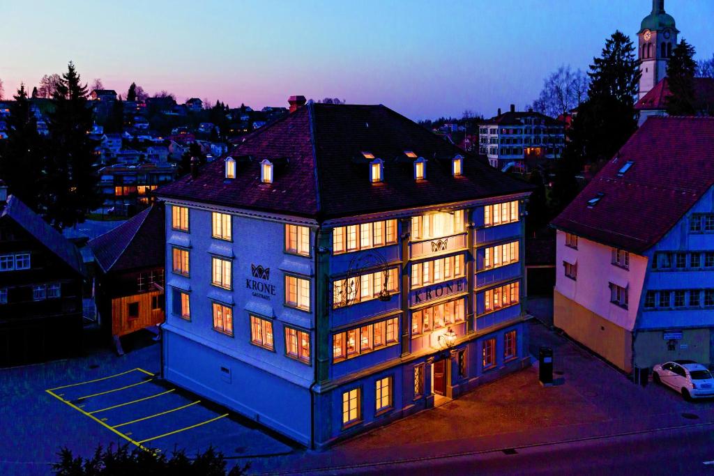 a large blue building with lights on at Hotel Krone Speicher in Speicher