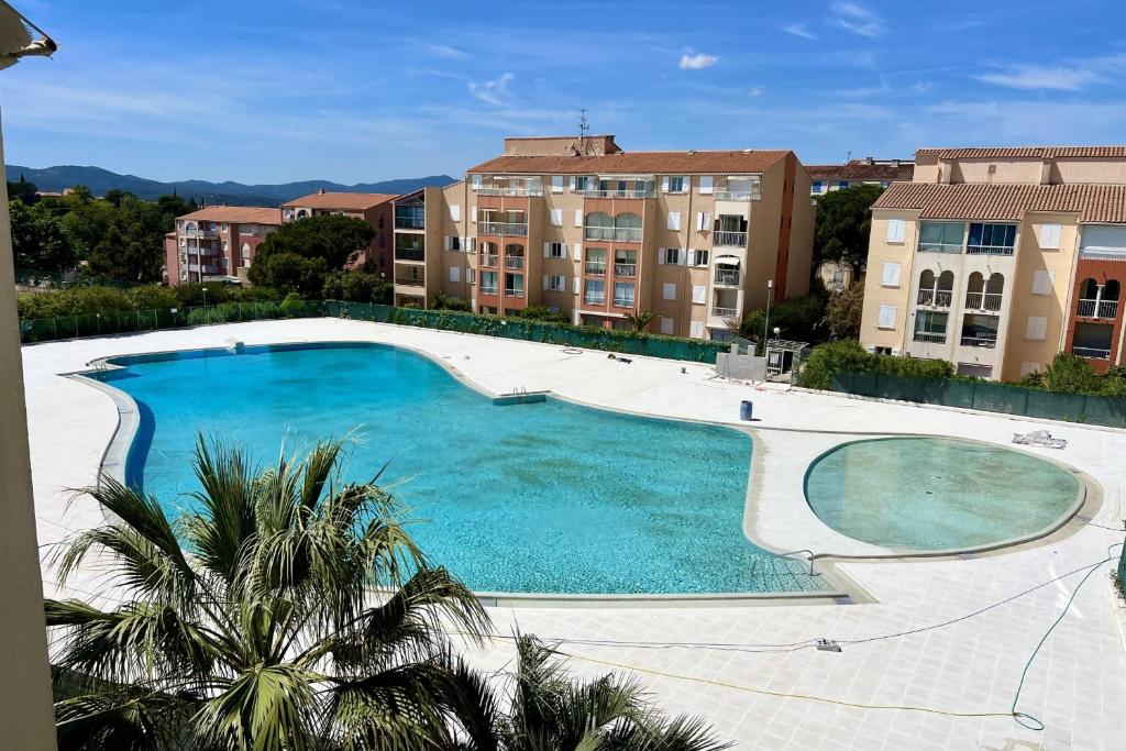 une grande piscine devant certains bâtiments dans l'établissement Bright 26 m with pool in Frejus, à Fréjus