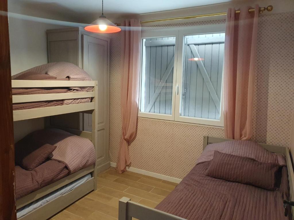 sypialnia z dwoma łóżkami piętrowymi i oknem w obiekcie Villa au coeur des vignes w mieście Le Luc