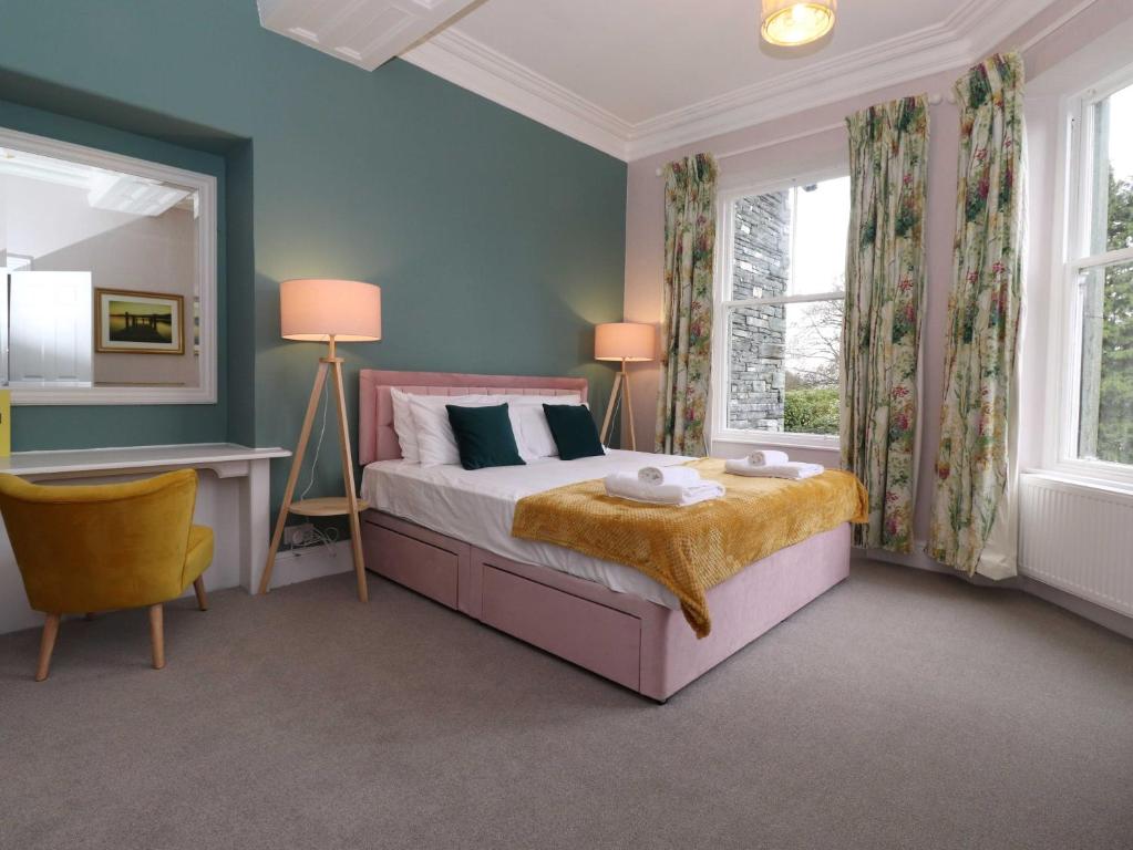 a bedroom with a bed and a desk and windows at Redwood Rise Apartment Keswick in Keswick