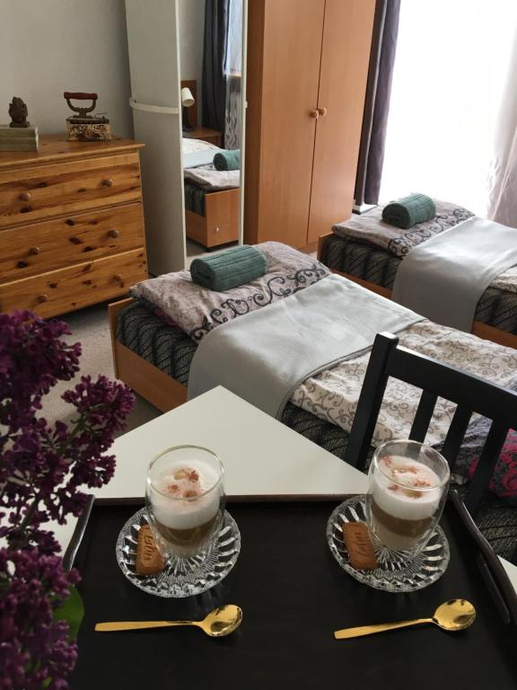 a room with two beds and a table with two cups of coffee at Willa Ewa in Busko-Zdrój