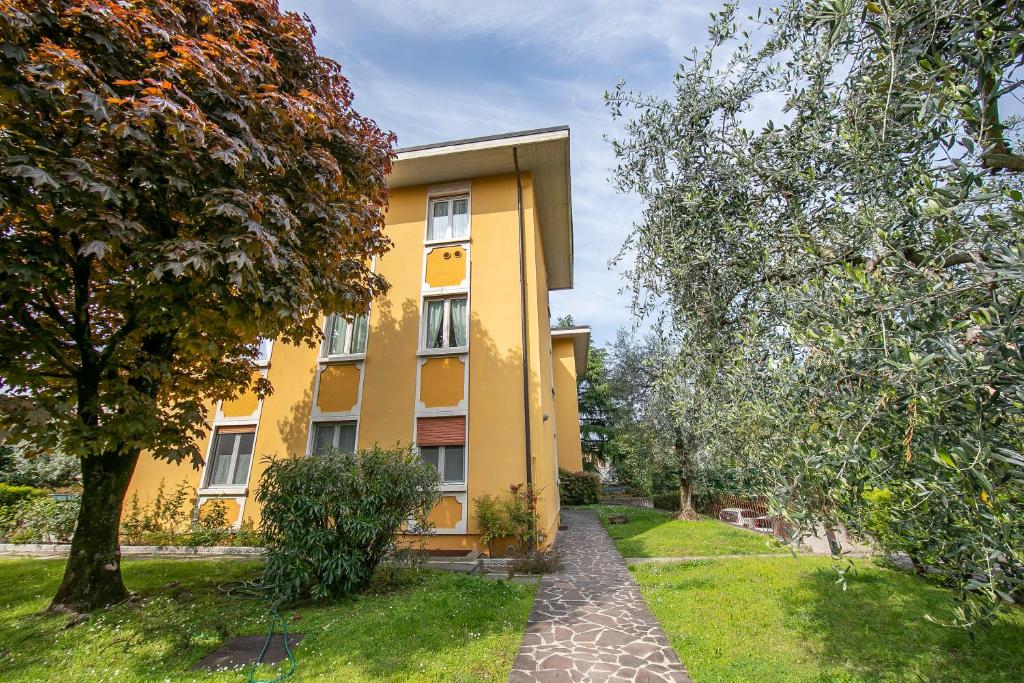een geel gebouw met een loopbrug ervoor bij Elena Apartment - Family Friendly - Happy Rentals in Salò