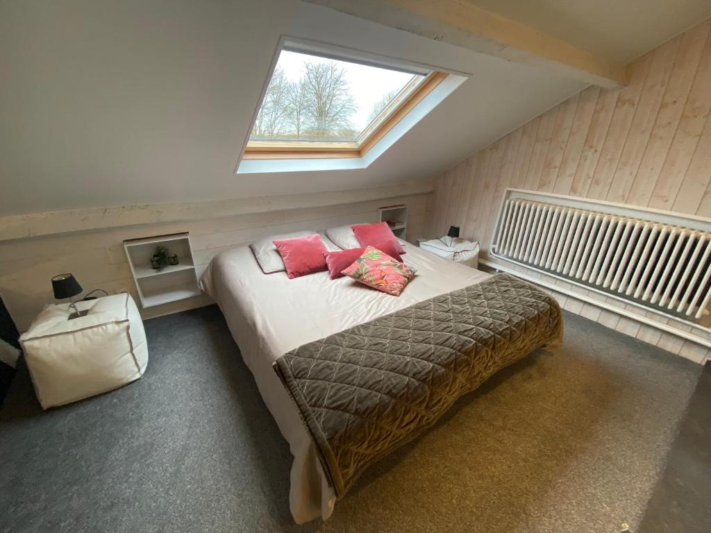 een slaapkamer met een bed met 2 kussens en een raam bij B&B 't zwart peird in Poperinge