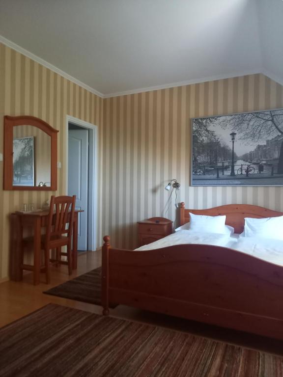 a bedroom with a bed and a desk and a chair at Európa Panzió in Eger