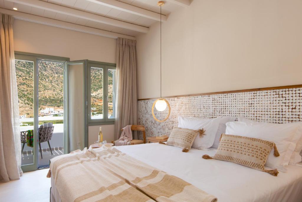 Schlafzimmer mit einem großen weißen Bett und einem großen Fenster in der Unterkunft Sunlight in Kamarai