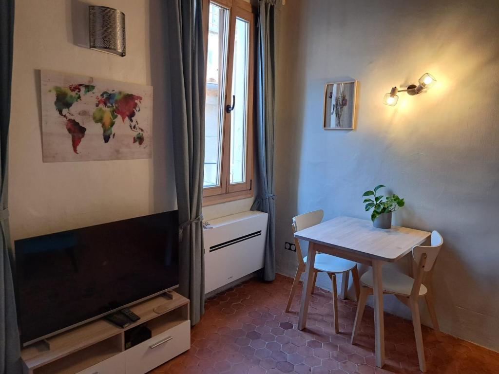 een woonkamer met een tafel en een televisie bij Renovated fully equipped studio for 2 to 4 pers in La Ciotat