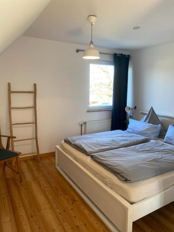 a bedroom with a bed with a ladder and a window at Nolte Faarderhuuch 7 in Norddorf