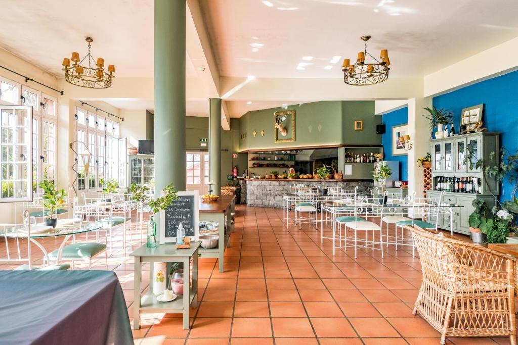 een restaurant met tafels en stoelen en een bar bij Villa Alto Boutique Hotel in Ponta do Sol