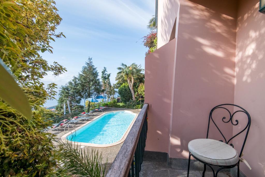 een balkon met een zwembad en 2 stoelen bij Villa Alto Boutique Hotel in Ponta do Sol