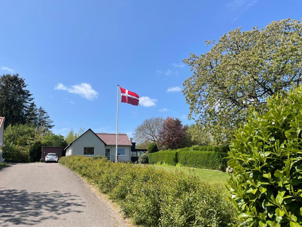 a canadian flag flying over a house on a driveway at Cozy Nature House in Svendborg