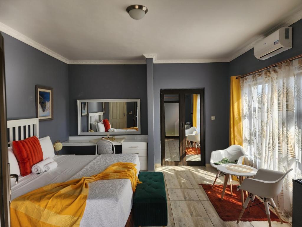 1 dormitorio con paredes azules, 1 cama y 1 mesa en Minnestay Guest House, en Palapye