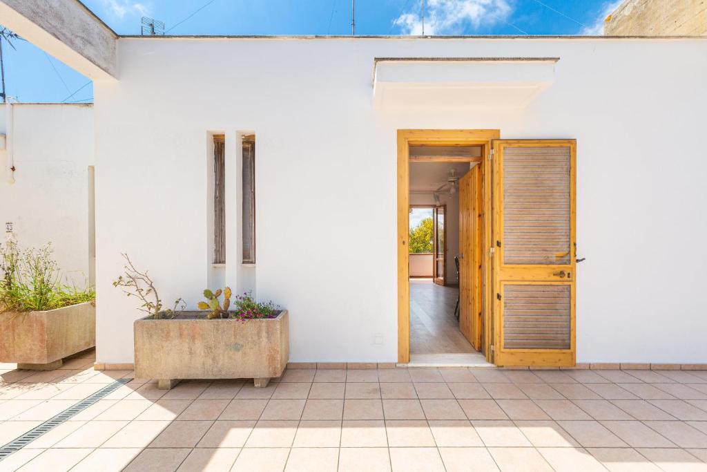 a white house with a wooden door at Casa di Gino` by BarbarHouse in San Foca