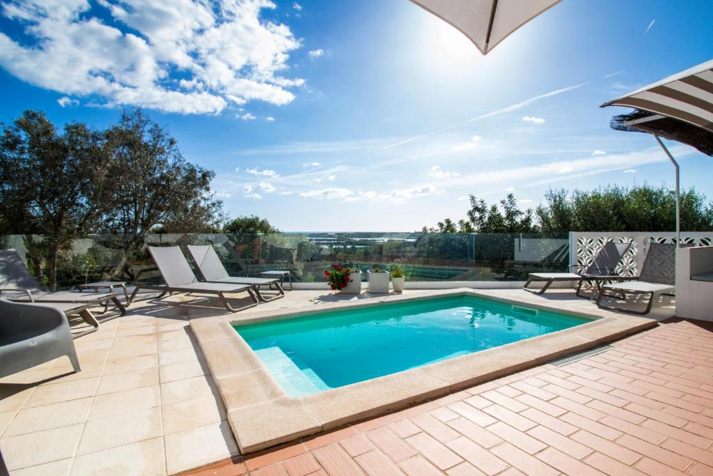 a swimming pool on a patio with lounge chairs and a patio table at Quinta da Felicidade, Casa Estrela in Guia