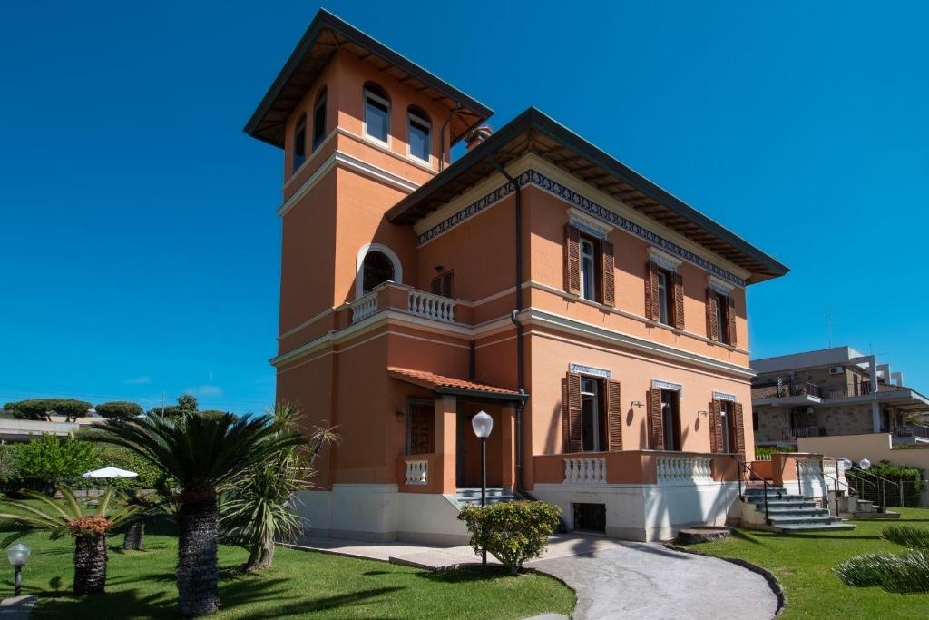 ein großes braunes Gebäude mit einem Uhrturm in der Unterkunft Palazzo Moresco in Santa Marinella
