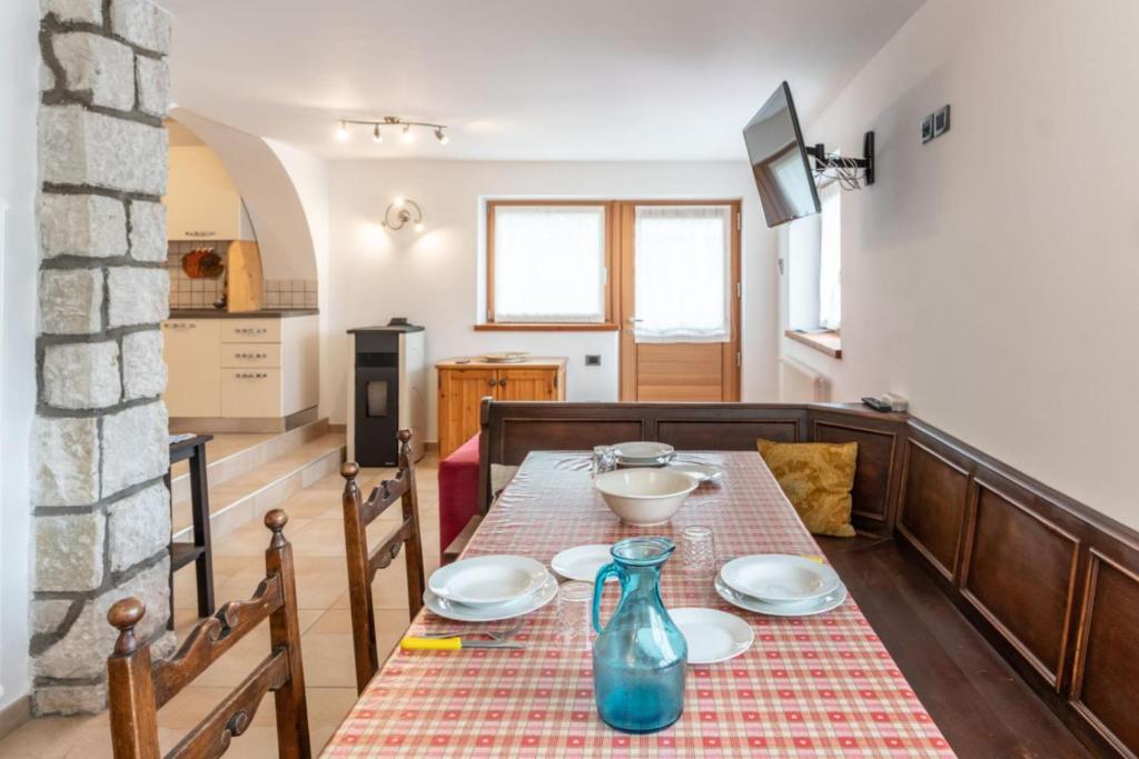 uma sala de jantar com uma mesa com pratos em Casa al Lez, Cavareno Ospitar em Cavareno