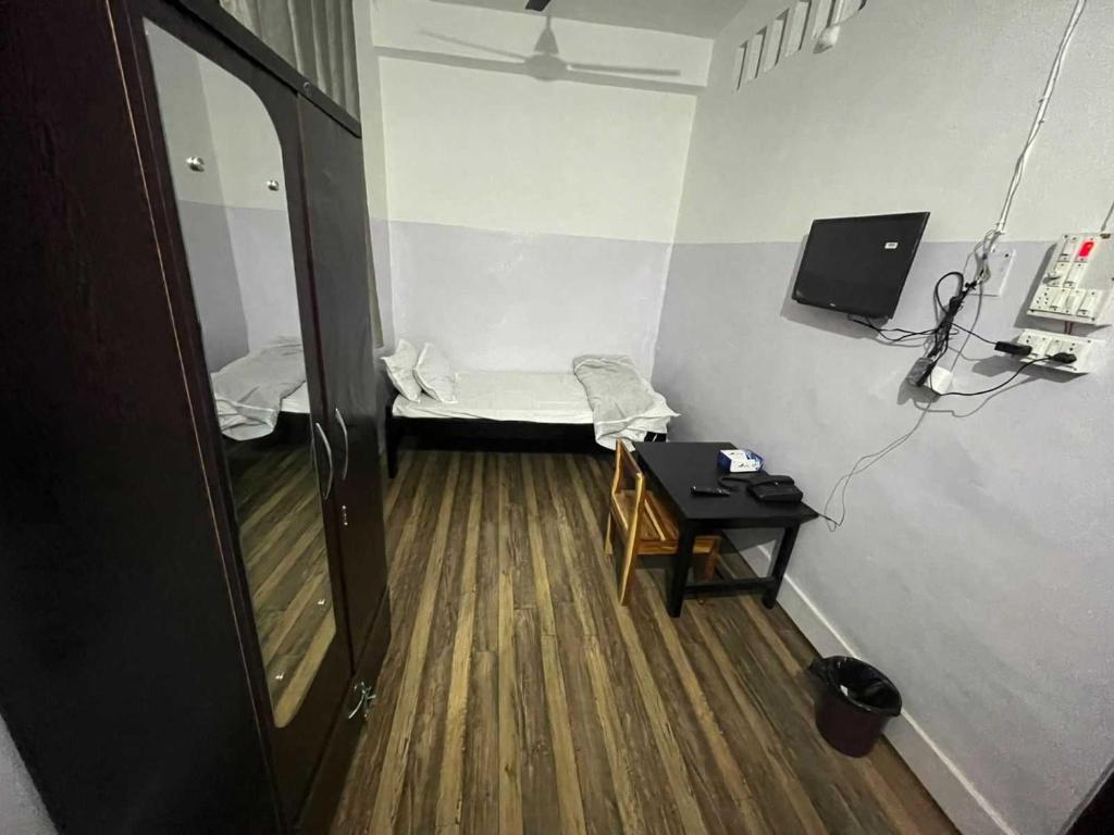a room with a bed and a table and a mirror at SPOT ON Hotel Mist in Dimāpur