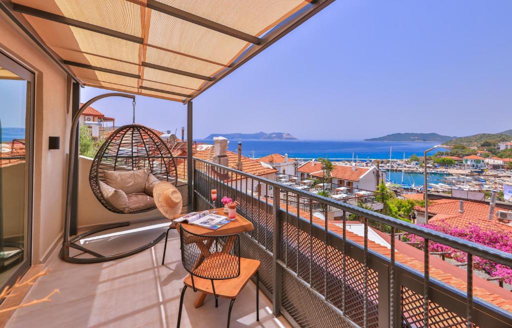 a balcony with a wicker chair and a table at Çınar Butik Hotel in Kaş