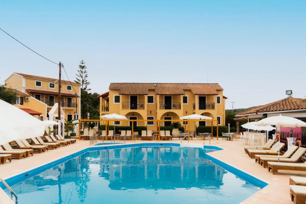 a pool at a resort with chairs and umbrellas at Oula Maisonettes Suites in Kavos