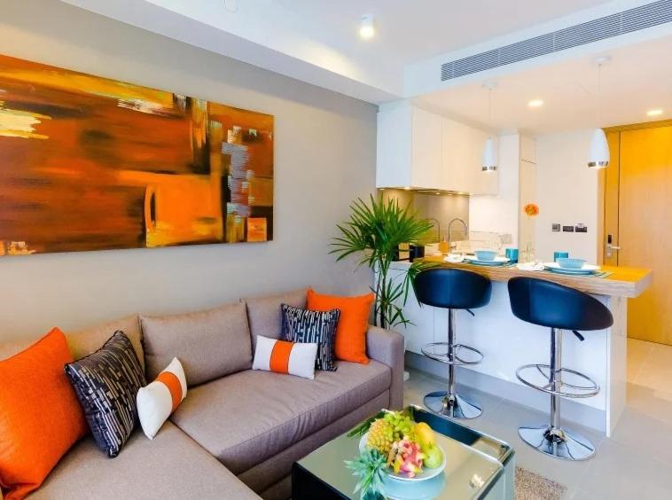 a living room with a couch and a kitchen at OceanStone 1-BR next building view in Bang Tao Beach