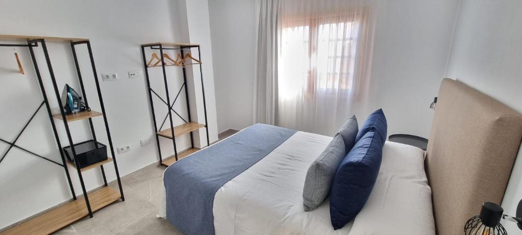 een slaapkamer met een bed en een bank met kussens bij ESTUDIO LA ESTRELLA in Candelaria