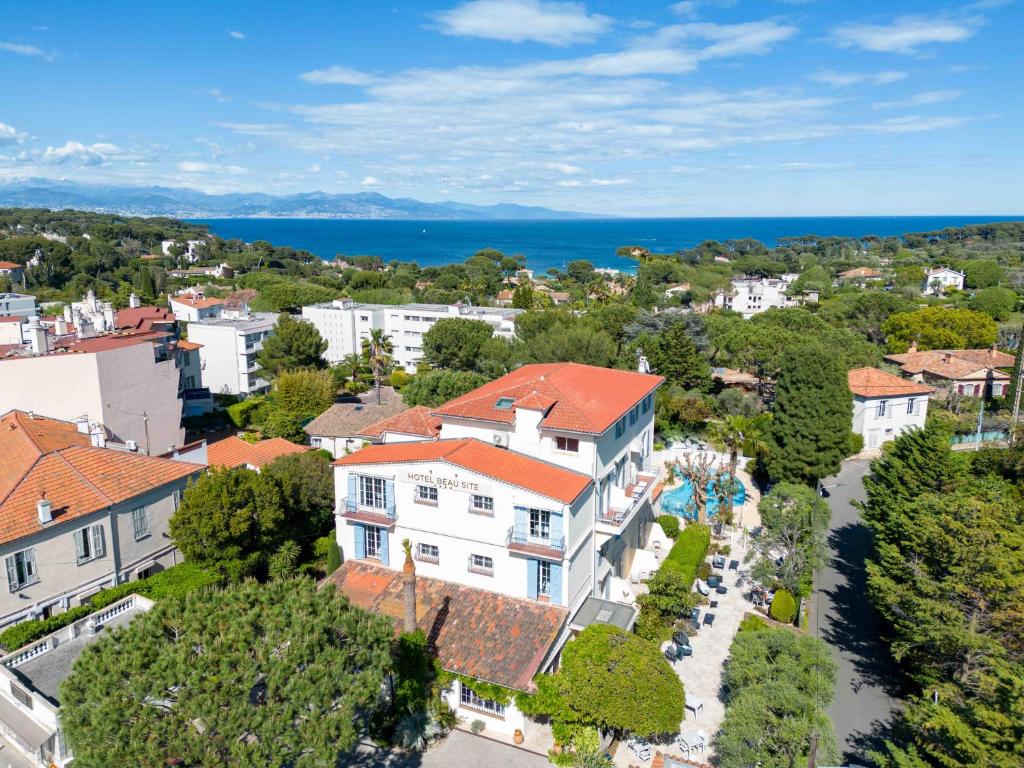 een luchtzicht op een stad met huizen en de oceaan bij Hôtel Beau Site - Cap d'Antibes in Antibes