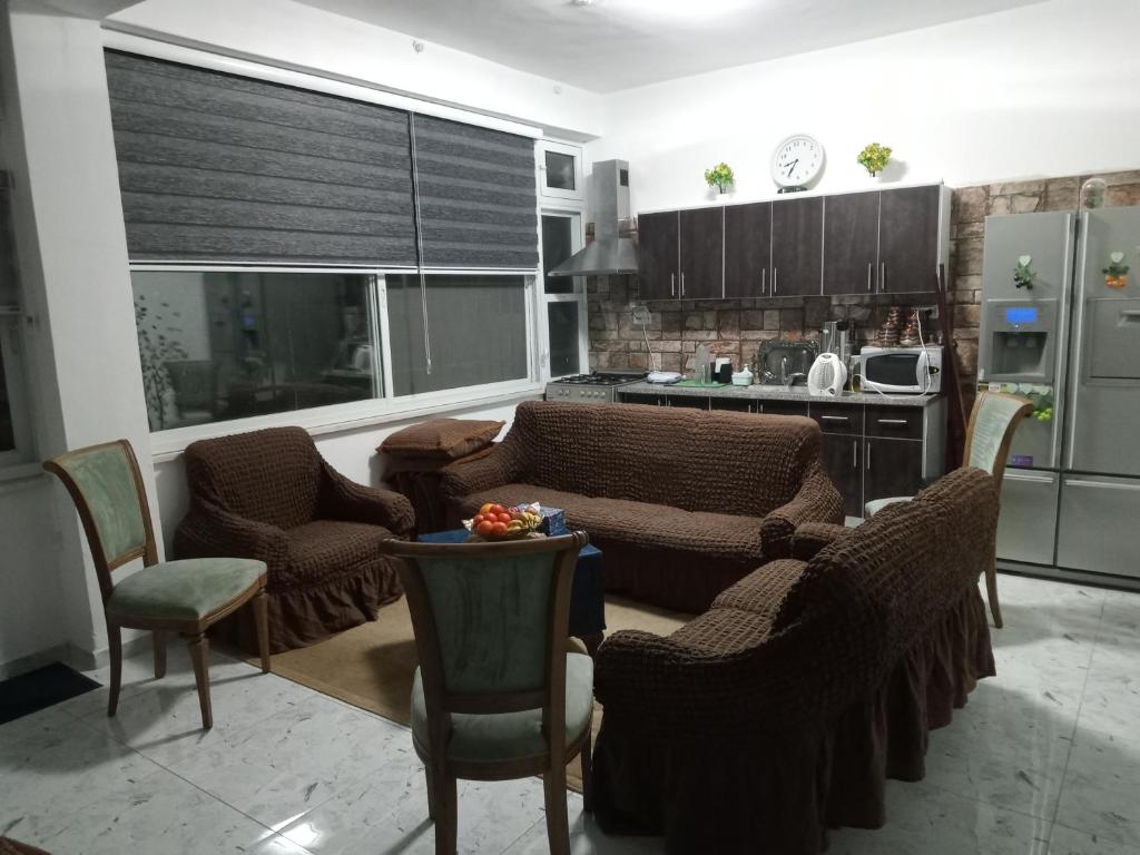 a living room with couches and chairs and a kitchen at بيت ضيافة حنضلة in Bethlehem