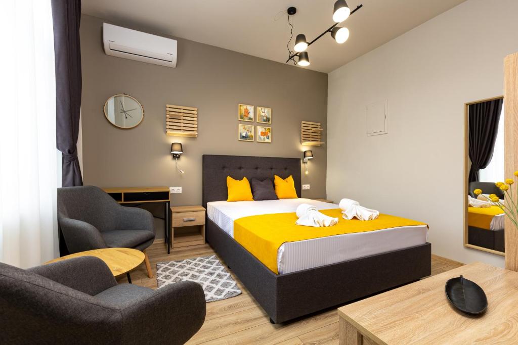 a bedroom with a bed and two chairs at Kapana Guest House on Central Pedestrian street with Parking included in Plovdiv