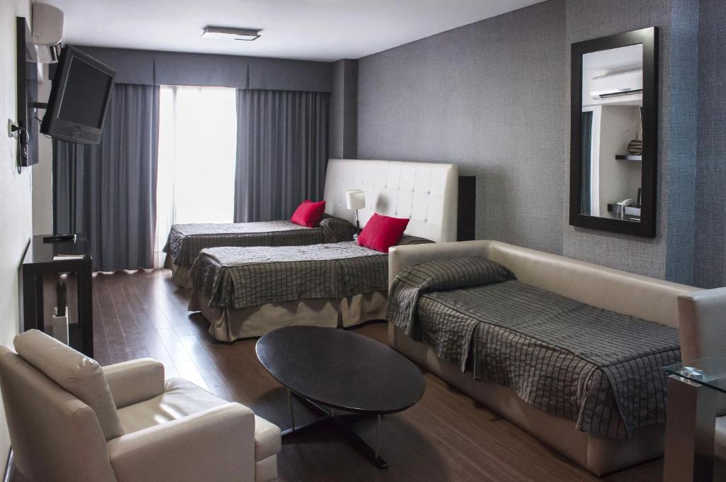 une chambre d'hôtel avec deux lits et un canapé dans l'établissement Guido 1980 by Ayres Apartments Recoleta, à Buenos Aires