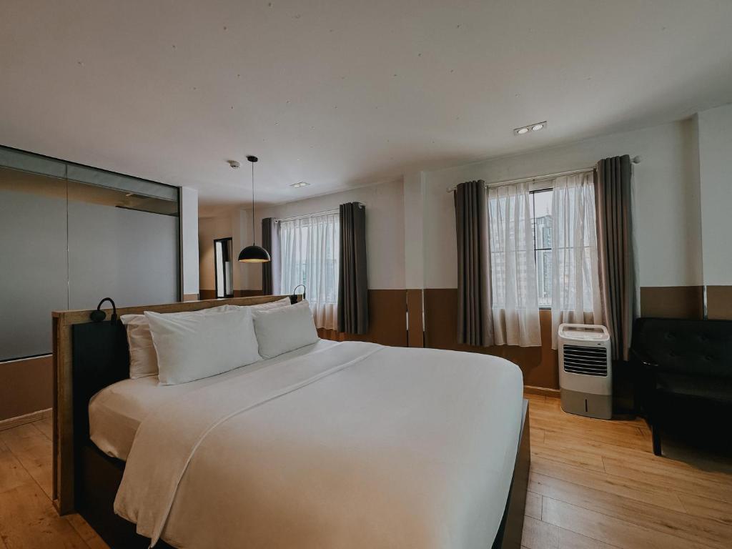 a large white bed in a hotel room at Chill Suites in Ho Chi Minh City