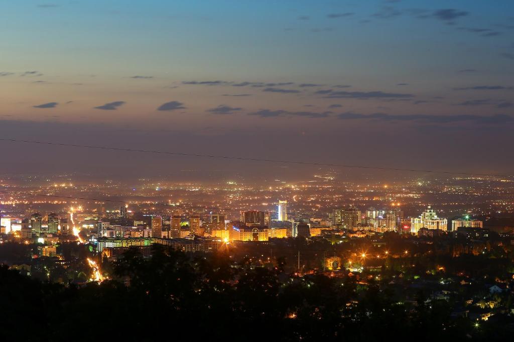 a view of a city at night with lights at Panorama Hills in Almaty