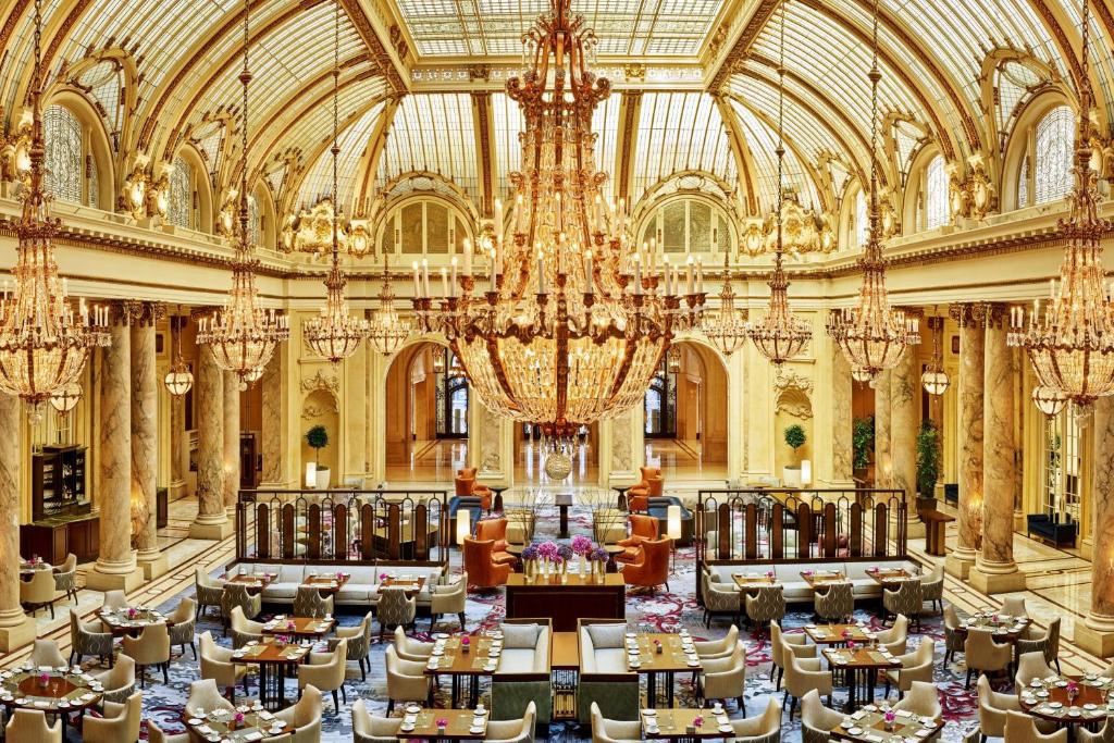 a large room with tables and chandeliers in a building at Palace Hotel, a Luxury Collection Hotel, San Francisco in San Francisco