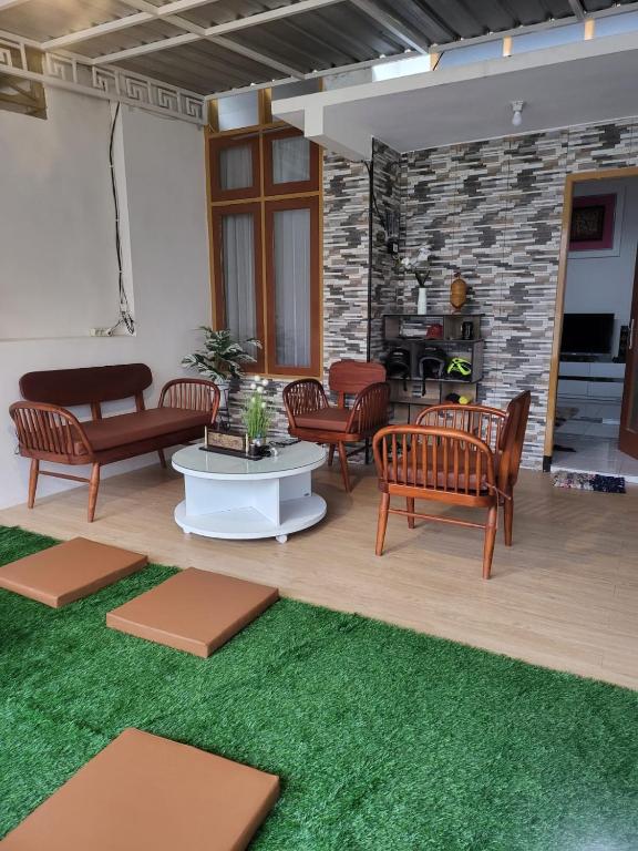a living room with chairs and a table with a green rug at SAMARA VILLA in Batu