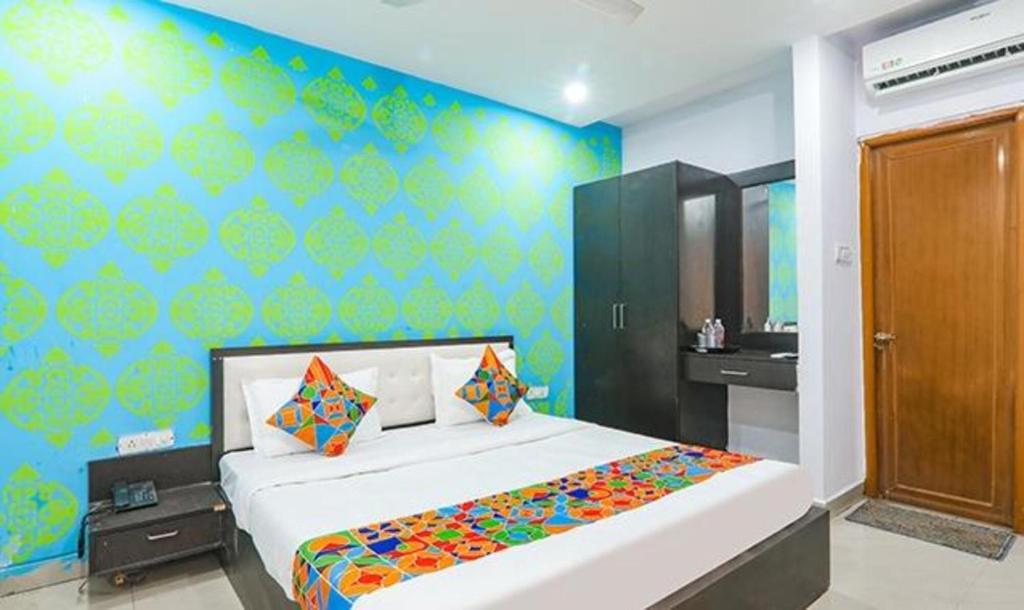 1 dormitorio con 1 cama grande y pared azul en FabExpress Happy Mark Inn, en Lucknow